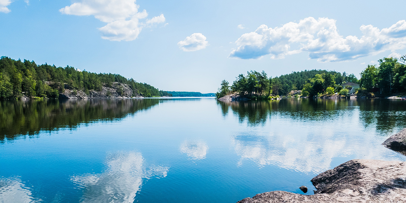 Utsikt över sjö med moln som speglas i sjön