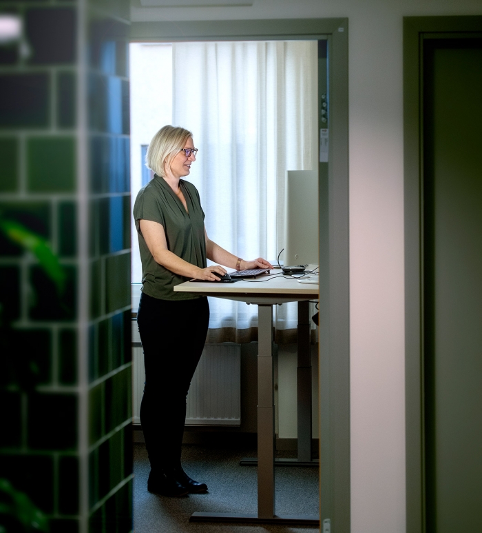 Martina står vid sin dator och kollar på sin datorskärm