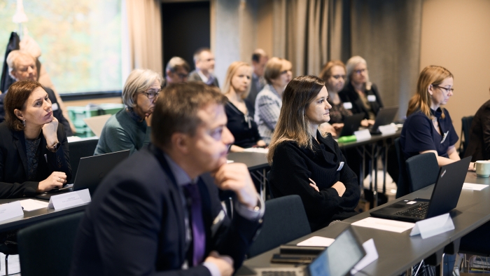 En sal med många personer som sitter och kollar mot scenen.